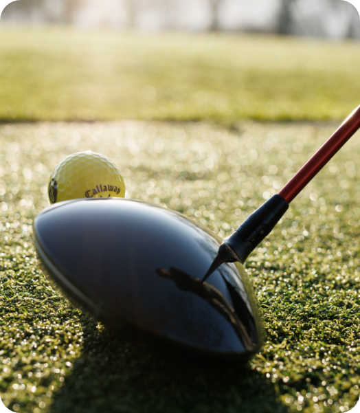 A golf ball on a tee with a club