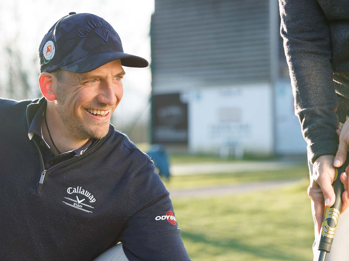 Zwei Personen mit Golfschlägern auf dem Golfplatz